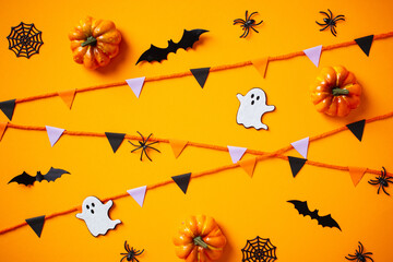 Wall Mural - Cute Halloween concept with paper garland, ghosts, bats, spiders, pumpkins on orange background.