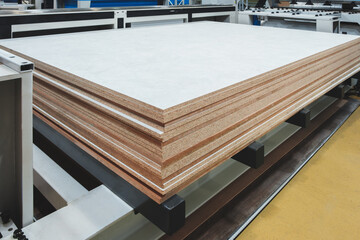 Poster - A stack of wood planks is on a conveyor belt. The wood is brown and white