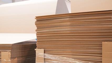 Poster - A stack of cardboard boxes with a plastic wrap on top. The boxes are piled up and appear to be in a warehouse