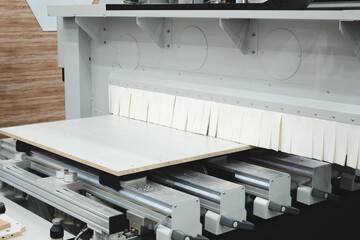Poster - A woodworking shop with a large machine cutting a piece of wood. The machine is surrounded by a lot of dust and debris
