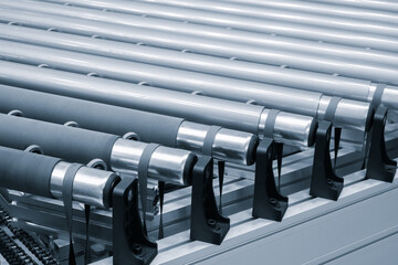 Poster - A row of metal tubes with rubber bands on them. The tubes are lined up in a row and are all the same size