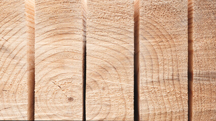 Poster - A pile of wood with a saw blade in the background. The wood is cut into pieces and is stacked on top of each other