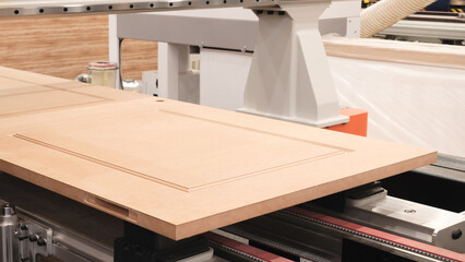 Poster - A piece of wood is being cut by a machine. The wood is brown and has a grain pattern