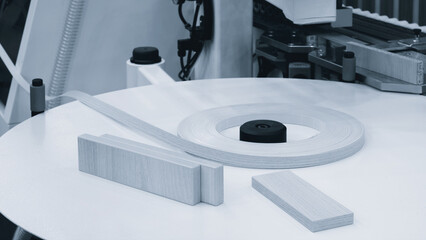 Poster - A machine is cutting a strip of wood. The machine is surrounded by other machines