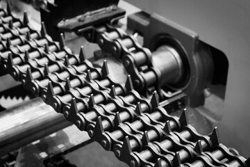 Aufkleber - A chain of metal links with many spikes. The chain is black and white. The chain is being made in a factory