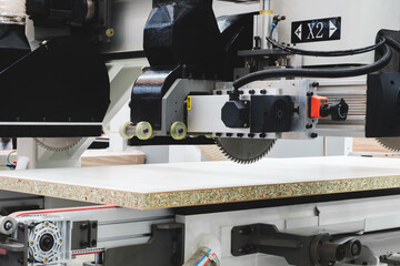 Poster - A woodworking shop with a large machine cutting a piece of wood. The machine is surrounded by a lot of dust and debris