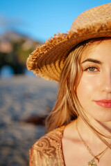 Wall Mural - Portrait of one young beautiful woman looking at the camera with big blue and green eyes. Female girl at the beach close up face.