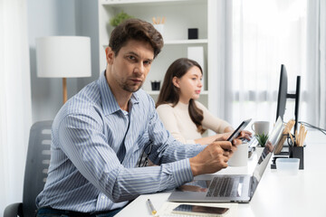 Wall Mural - Office worker smart man using tablet and pen to search looking at camera photo shooting portrait business using pen to pose profile with beautiful coworker at modern office at morning time. Postulate.