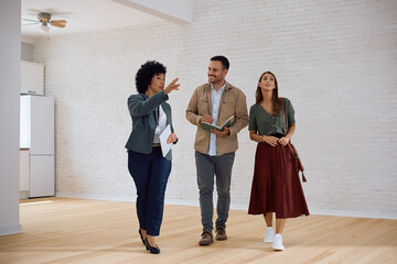 real estate agent showing new apartment to couple during open house day.