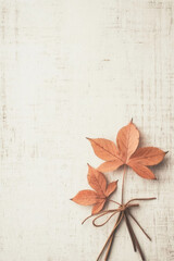 Wall Mural - Watercolor illustration of two autumn leaves tied with a string on a light textured background. Includes copy space.