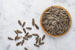 © Yuliia - Gray sunflower seeds with salt in a wooden bowl on a light background.  Top view, horizontal.