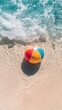 © cac_tus - Colorful beach ball on sand with ocean waves, summer vacation concept