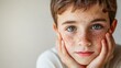 © Artyom - Portrait of boy with freckles, resting his face on hands