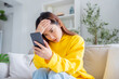 © Monster Ztudio - Bad news on device screen. Upset asian woman frustrated by problem with work or relationships, sitting on couch, feeling despair and anxiety, loneliness, having psychological trouble