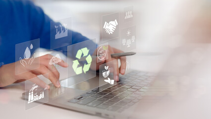 Women using a laptop with virtual icons related to recycling, renewable energy, and environmental protection. Sustainable development planning concept. ESG business sustainability investment strategy