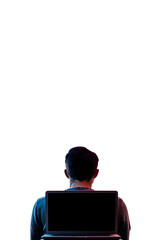 a person sits in front of a laptop, illuminated by colorful lights, symbolizing technology and moder
