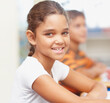 © STEEXBuyout/peopleimages.com - Smile, portrait and girl in classroom for writing test, growth and child development at elementary school. Happy, face and student at desk for kids education, study and assessment for scholarship.