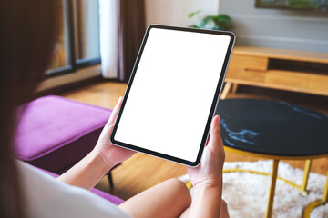 Wall Mural - Mockup image of a woman holding digital tablet with blank desktop screen at home