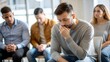 © NHA Studio - Sad Man in Support Group - A somber man sits among others in a support group.