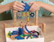 © AngArt - Girl assembles swing from magnetic wooden construction set. Toys and activiti children. Developmental activities at home.