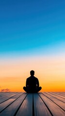 A serene silhouette of a person meditating at sunset, surrounded by vibrant sky colors reflecting calmness and inner peace.