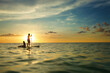 © Cavan Images - Sisters on paddle board at sunset Anna Maria Island