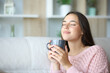 © Antonioguillem - Woman relaxing smelling coffee or tea at home