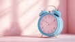 © Lexyat - Blue alarm clock with pink face on a pink background with light streaming in.