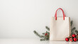 © Irina - White paper shopping bag, Christmas decor next to it, white background, empty space for text.