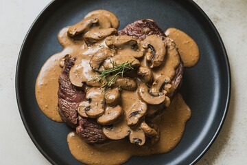 Wall Mural - close-up shot of a plate with a steak smothered in mushroom sauce