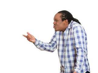 Closeup side portrait, headshot handsome young unhappy man, looking angry, agitated, pointing with finger, isolated white background. 