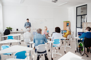 Sticker - Teacher explaining senior students how to work with laptop and internet. Elderly people attending computer and technology education class. Digital literacy.