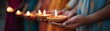 © ธนากร บัวพรหม - Group of hands holding traditional oil lamps, symbolizing festival celebration and spirituality in a vibrant and colorful setting.