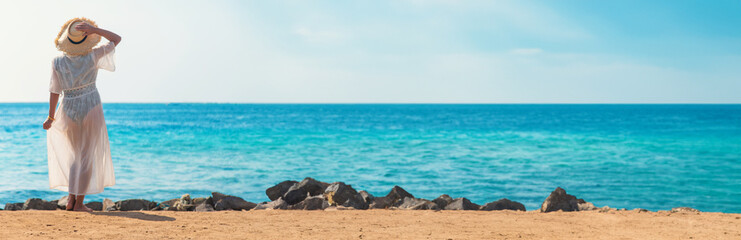 Wall Mural - Woman in a hat on the seashore. Selective focus.