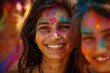 © chutikan - Group of happy smiling young women with colorful faces wearing colorful Holi festival outfits.