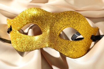 Sticker - Beautiful golden carnival mask on beige fabric, top view