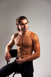 © Alex Vog - Handsome sporty guy fashion model with perfect sexy naked muscle torso posing sits on chair, smile looking away. Classy muscular man with muscles abs press on white studio backdrop. Copy ad text space