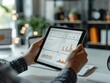 © Phoenix AI Photo - Person analyzing business analytics on a tablet screen with charts and graphs in a modern office setting.