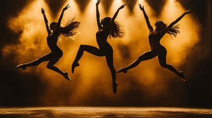 Poster - silhouettes of three female dancers leaping in the air under golden stage lights during a performance. 