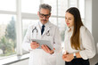 © Vadim Pastuh - A mature doctor with a digital tablet is having a conversation with a young female patient by a window with a city view, symbolizing a transparent and bright healthcare experience
