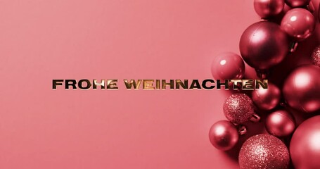 Wall Mural - Frohe weihnachten text in gold over pink christmas baubles on pink background