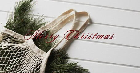 Canvas Print - Merry christmas text in red over bag with christmas tree branches on white wood background