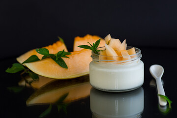 Wall Mural - sweet homemade yogurt in a jar with pieces of ripe melon