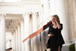 © Вероника Зеленина - A stylish girl of about twenty-five is walking around the city, a woman wearing a black dress, a jacket and glasses, the model is holding a phone in her hands