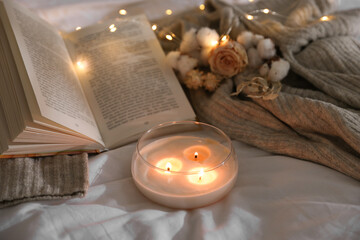 Sticker - Burning candle, book, sweater and dry flowers on white cloth. Autumn aesthetics