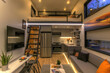 © Sunday Cat Studio - Modern sleek tiny house interior living room with loft bedroom, featuring bright lighting and contemporary furniture.