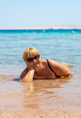 Wall Mural - Woman relaxing on the beach in the sea. Selective focus.