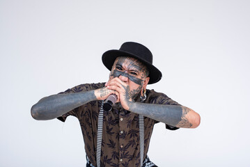 A Death metal vocalist growling on the microphone. A frontman full of face an body tattoos. Isolated on a white background.