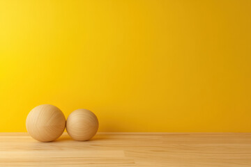 Poster - Minimalist wooden spheres on a wooden surface against a vibrant yellow background, creating a modern and artistic composition.