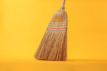 Wall Mural - One corn straw broom on orange background